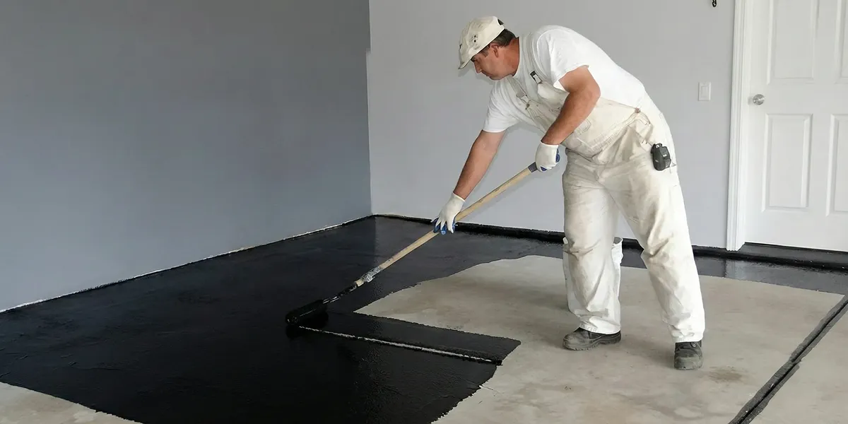basement waterproofing professional applying waterproof coating to protect a basement floor in Oakland, CA