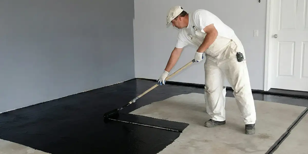 basement waterproofing professional applying waterproof coating to protect a basement floor in Oakland, CA